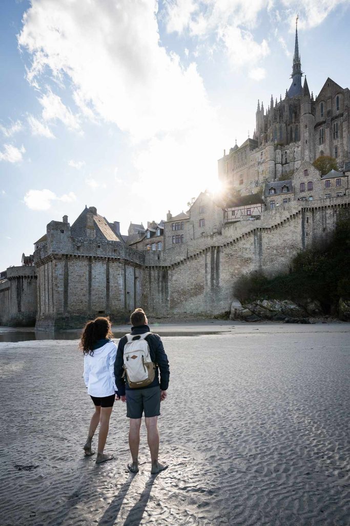 Couple marchant sur le sable devant le Mont-Saint-Michel