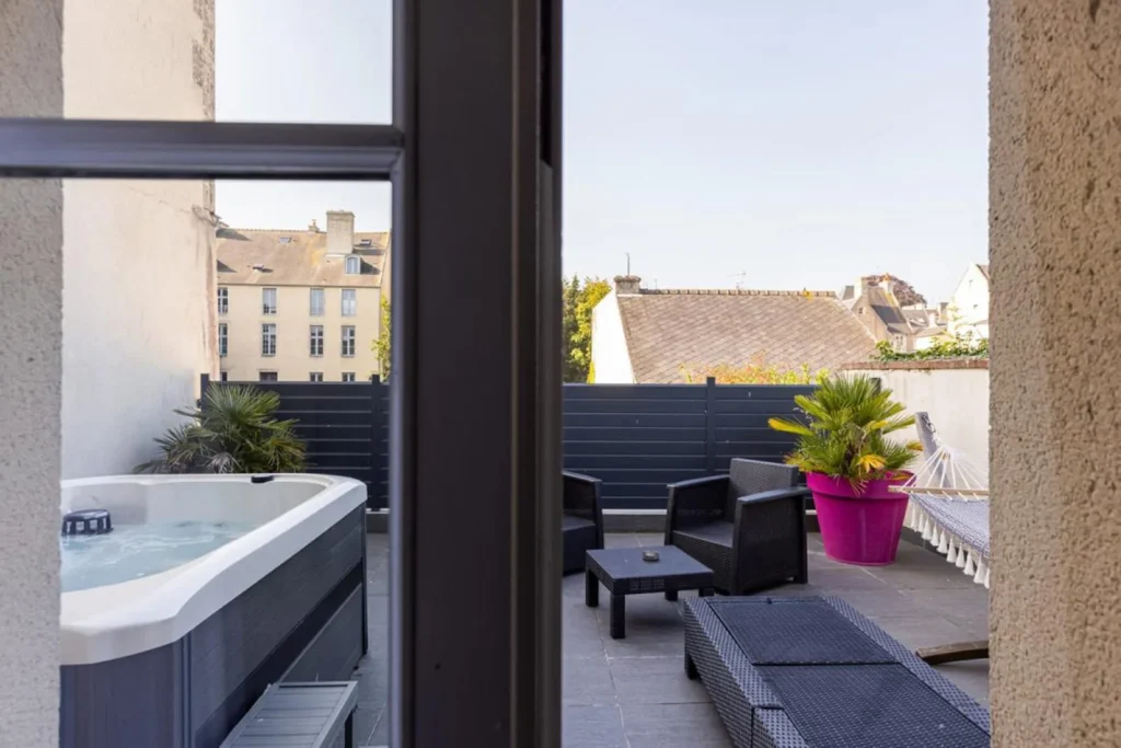 Grand Hôtel du Luxembourg à Bayeux, fenêtre ouverte sur un grand balcon avec bain à remous
