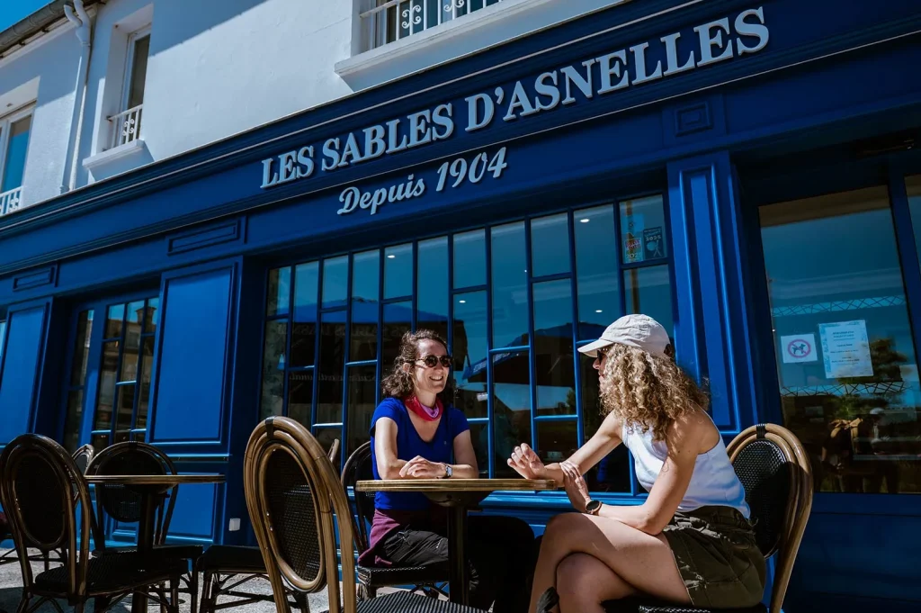 Deux amies attablées devant la boutique Les Sablés d