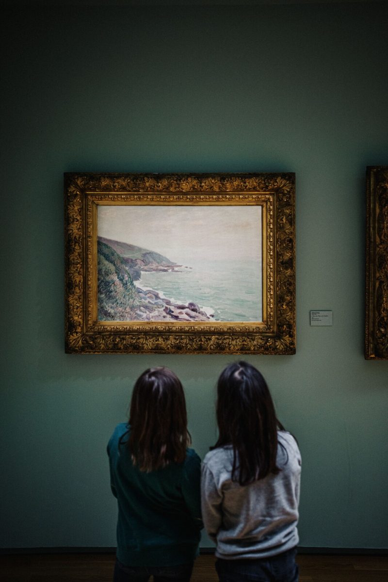 Deux enfants regardant le tableau "Côtes du Pays de Galles" de Sisley.
